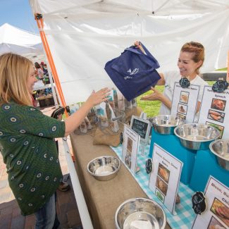 woman buying dog food at a farmers market