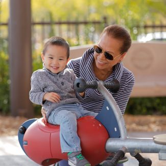 young kid enjoying playground with mom