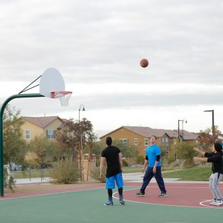 boys playing basketball at park