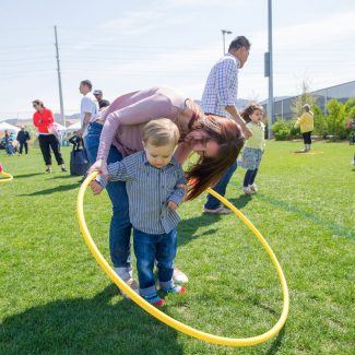 mom teaching son how to hula hoop