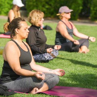 women doing yoga in park