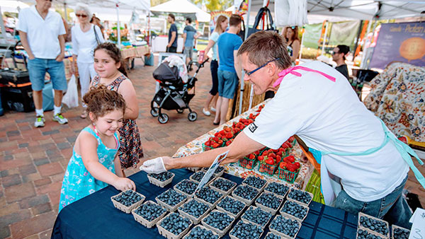 man giving girl blueberries