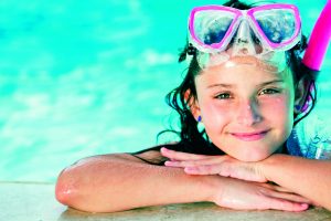 smiling girl in pool wearing snorkel