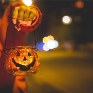 child's hand holding halloween bucket