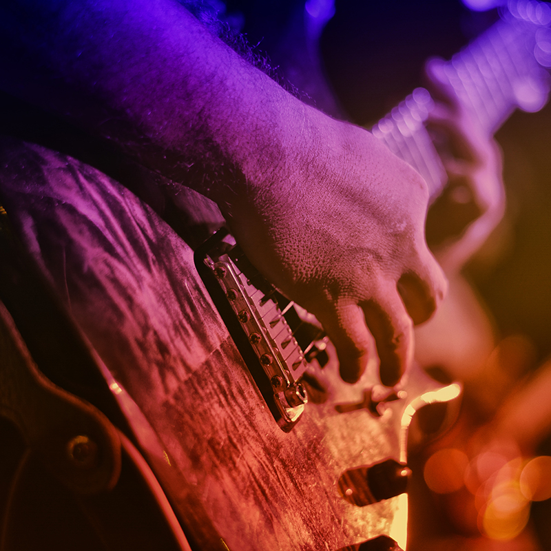 close up of hand playing a guitar