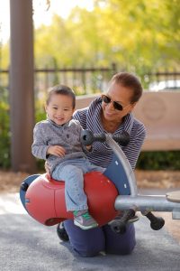 young kid enjoying playground with mom