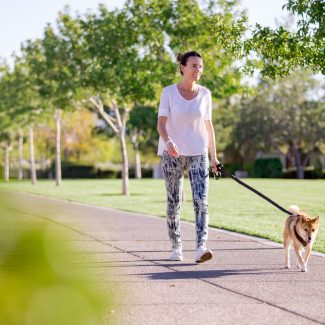 woman walking dog through park