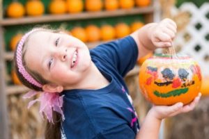 girl showing off painted pumpkin