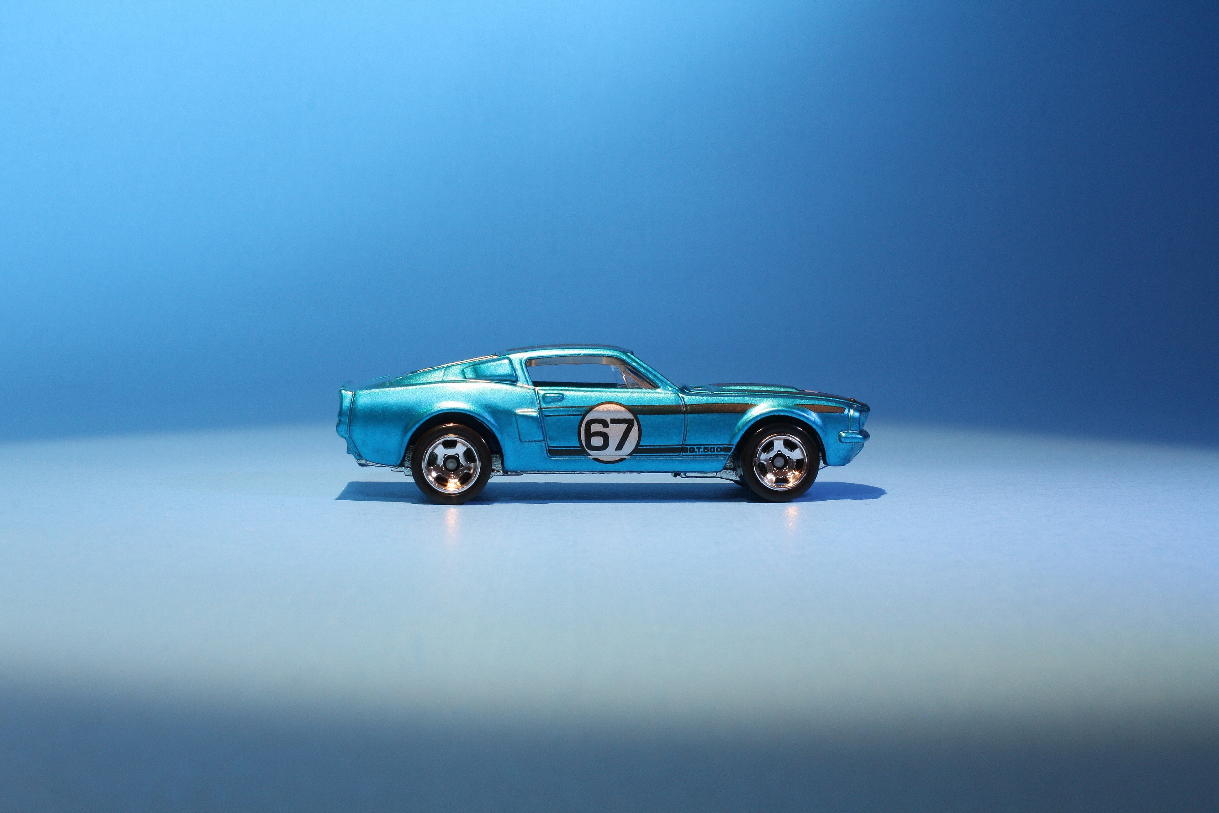 Blue die cast car painted with a number 87 sits in front of a blue backgroun.