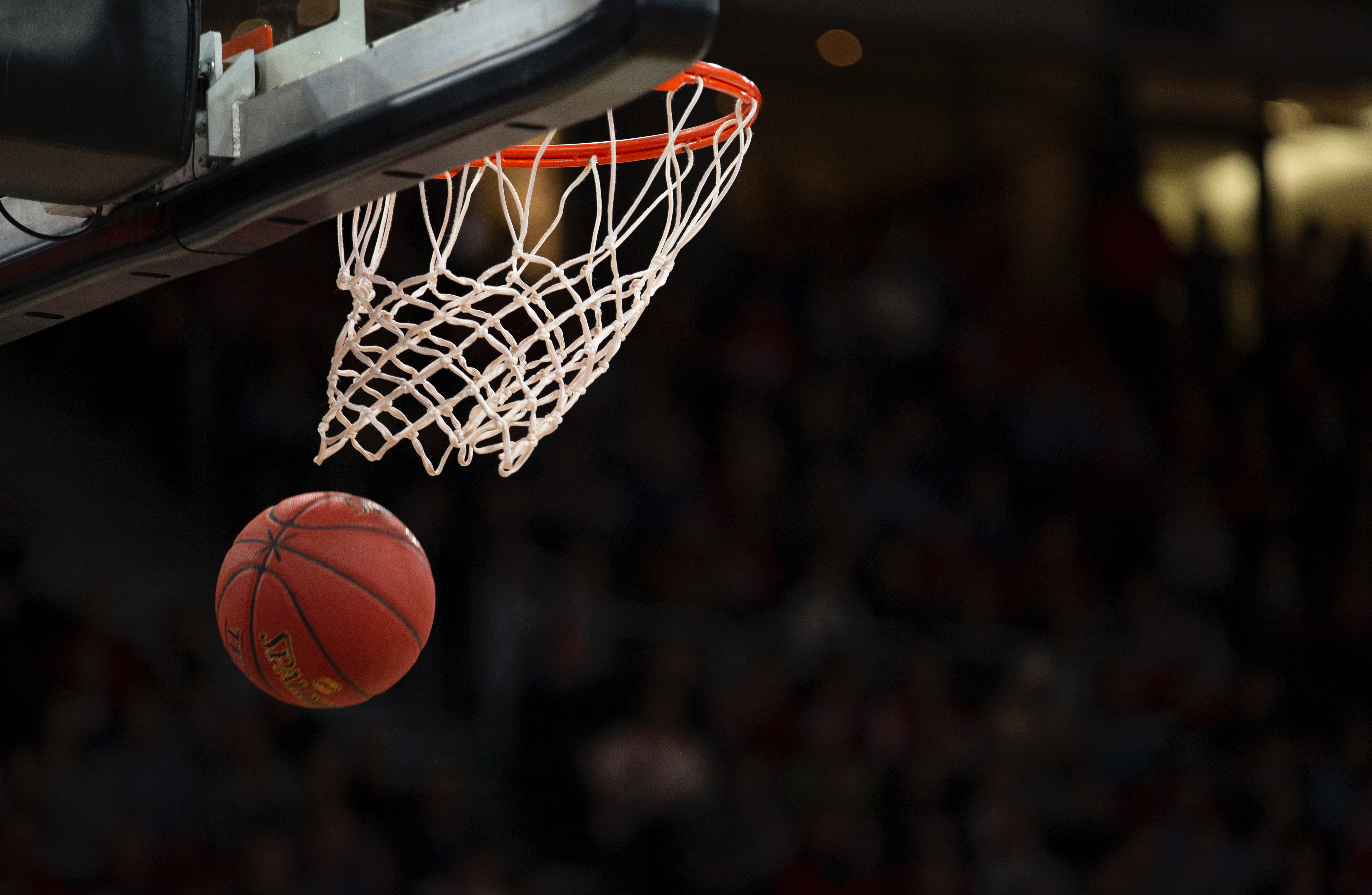 A basketball falls through the net of a basketball hoop