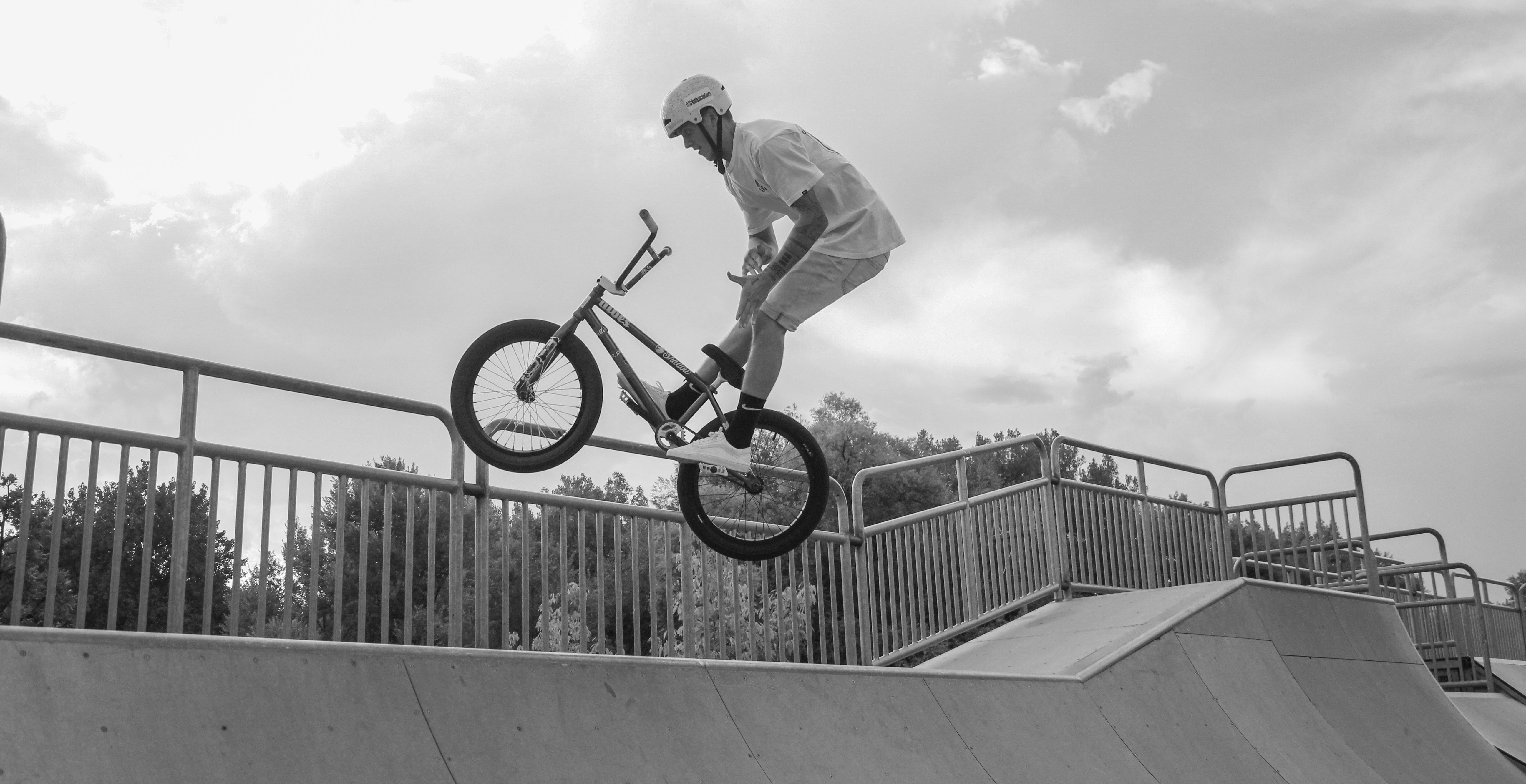 A man performs a BMX bike trick on a ramp