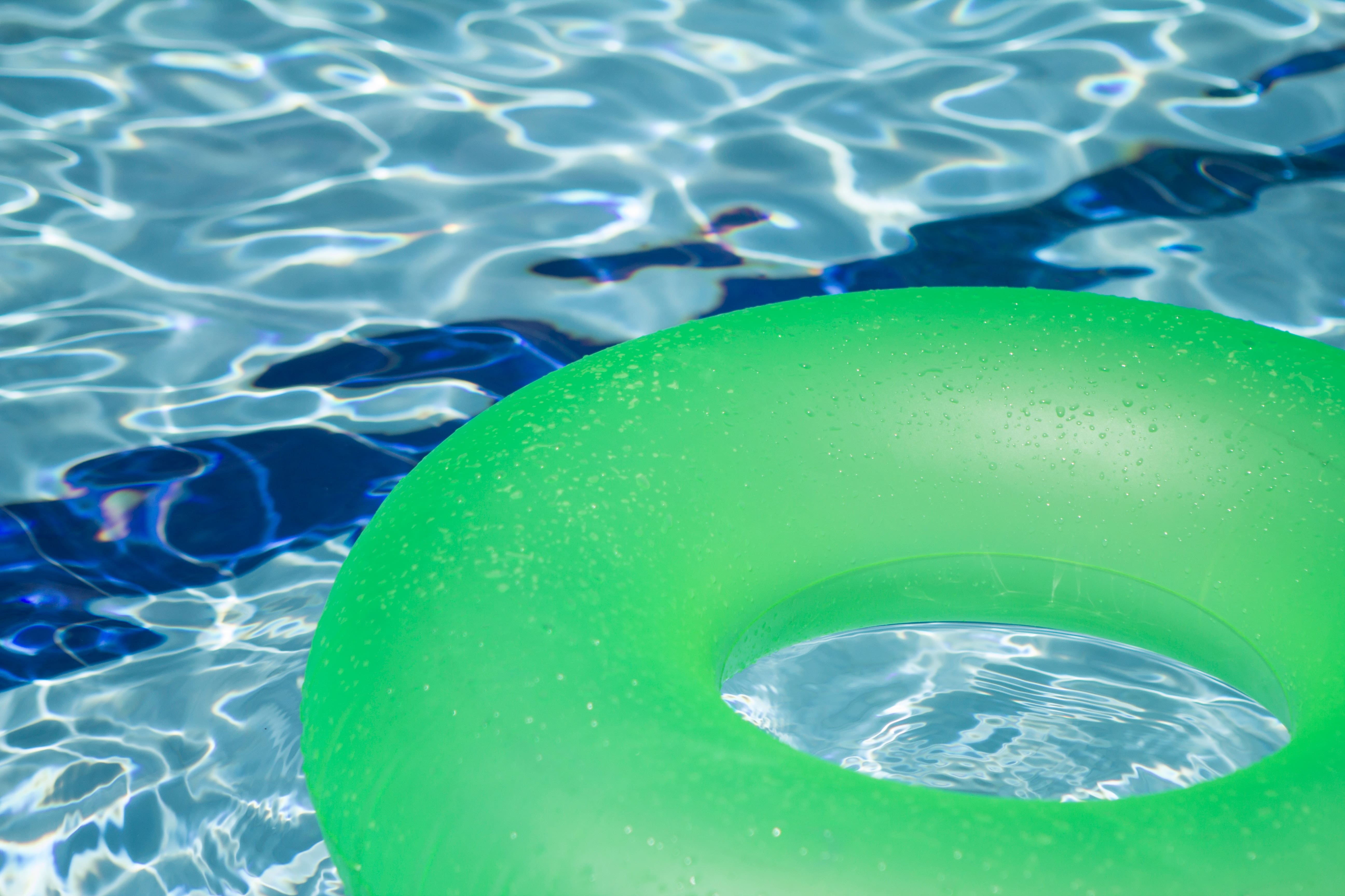A green pool floatie floats in the water during the Mighty Medley event