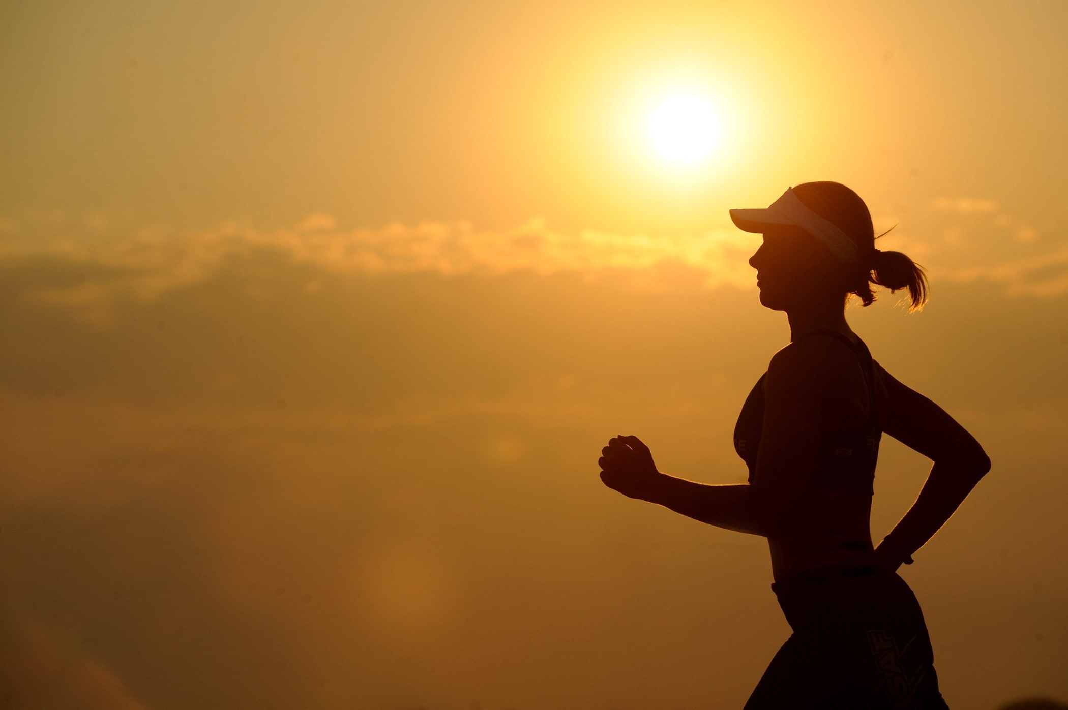A women runs with the sunset in the background