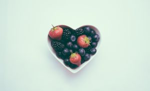 A heart-shaped bowl with strawberries and blueberries