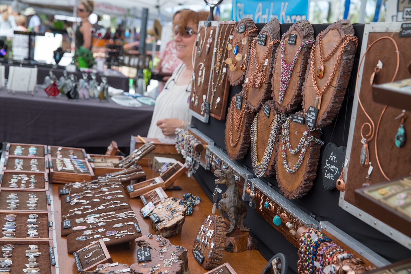 Colorful pieces of hand-crafted jewelry hang in a booth