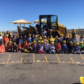 kids sitting in parking lot in front of construction