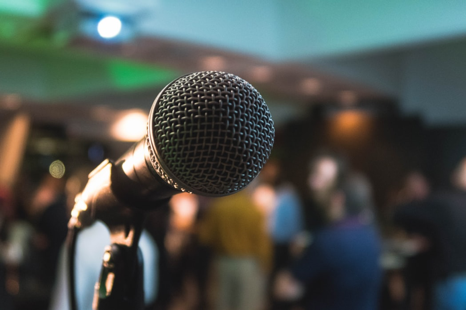 A microphone stand in front of a crowd.