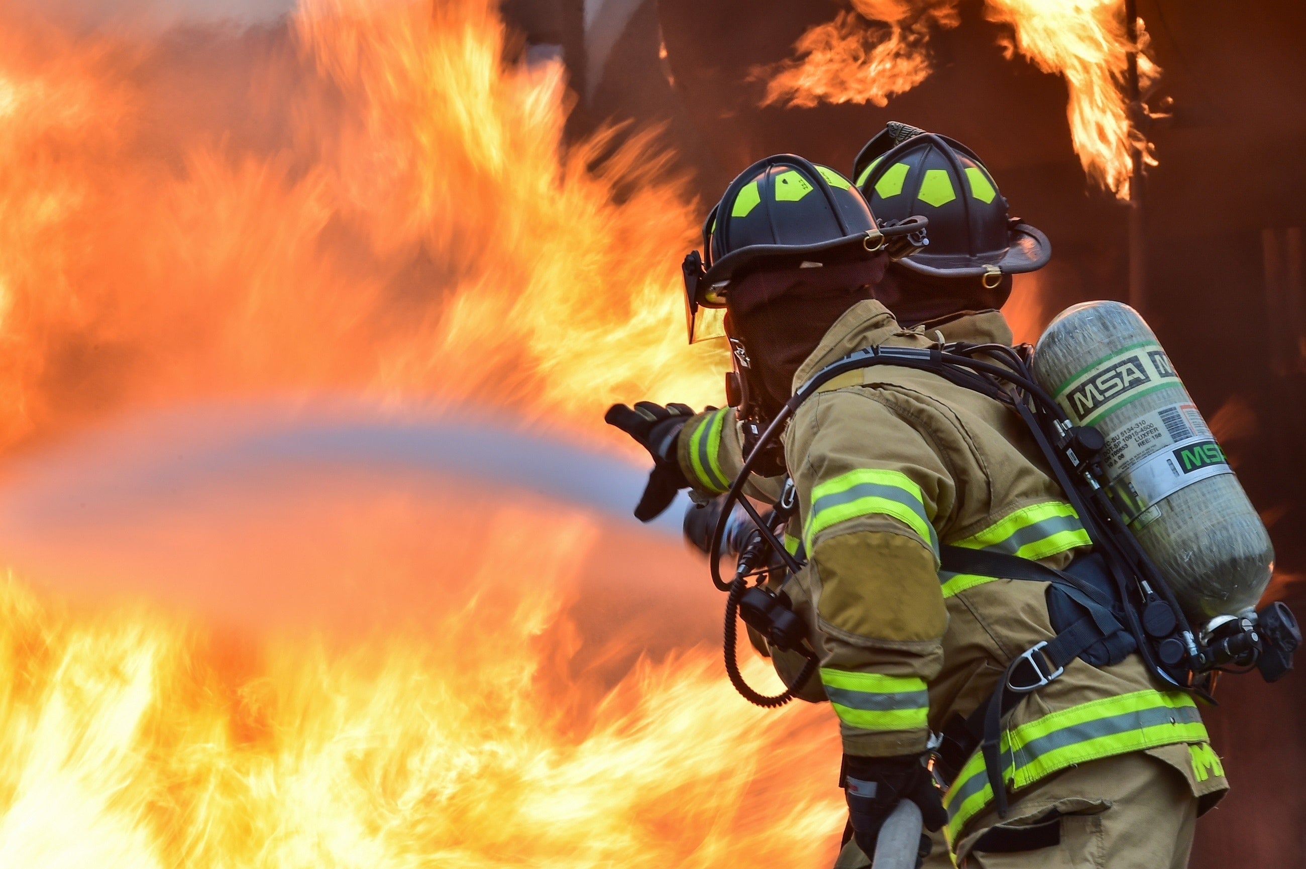 Two firefighters put out a fire