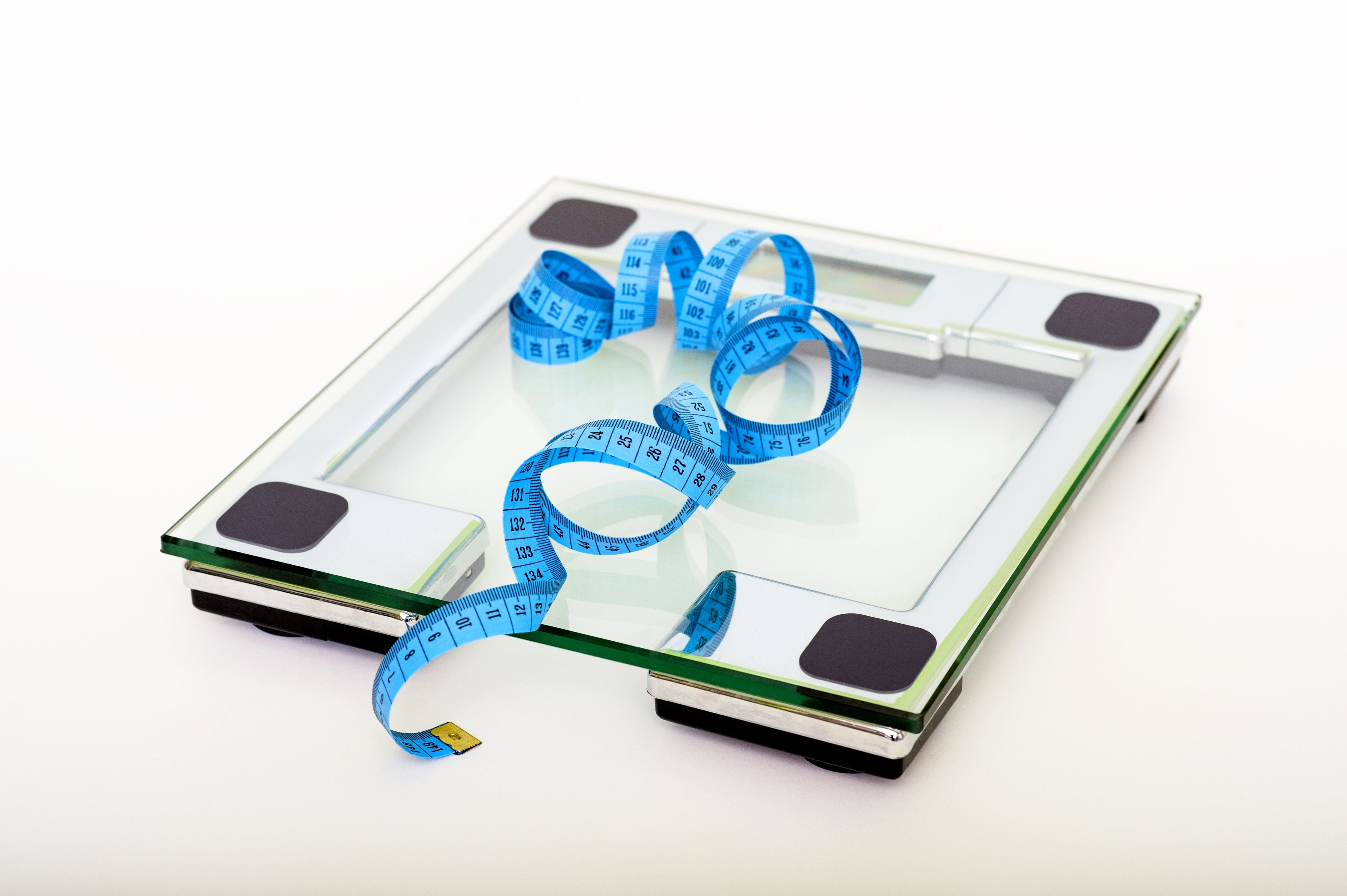 A blue measuring tape sits on a glass scale