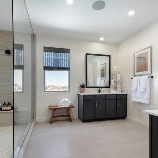 Master bathroom with glass door shower and two sinks.