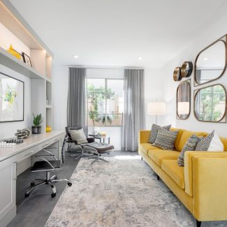 Office room with yellow couch and natural lighting.