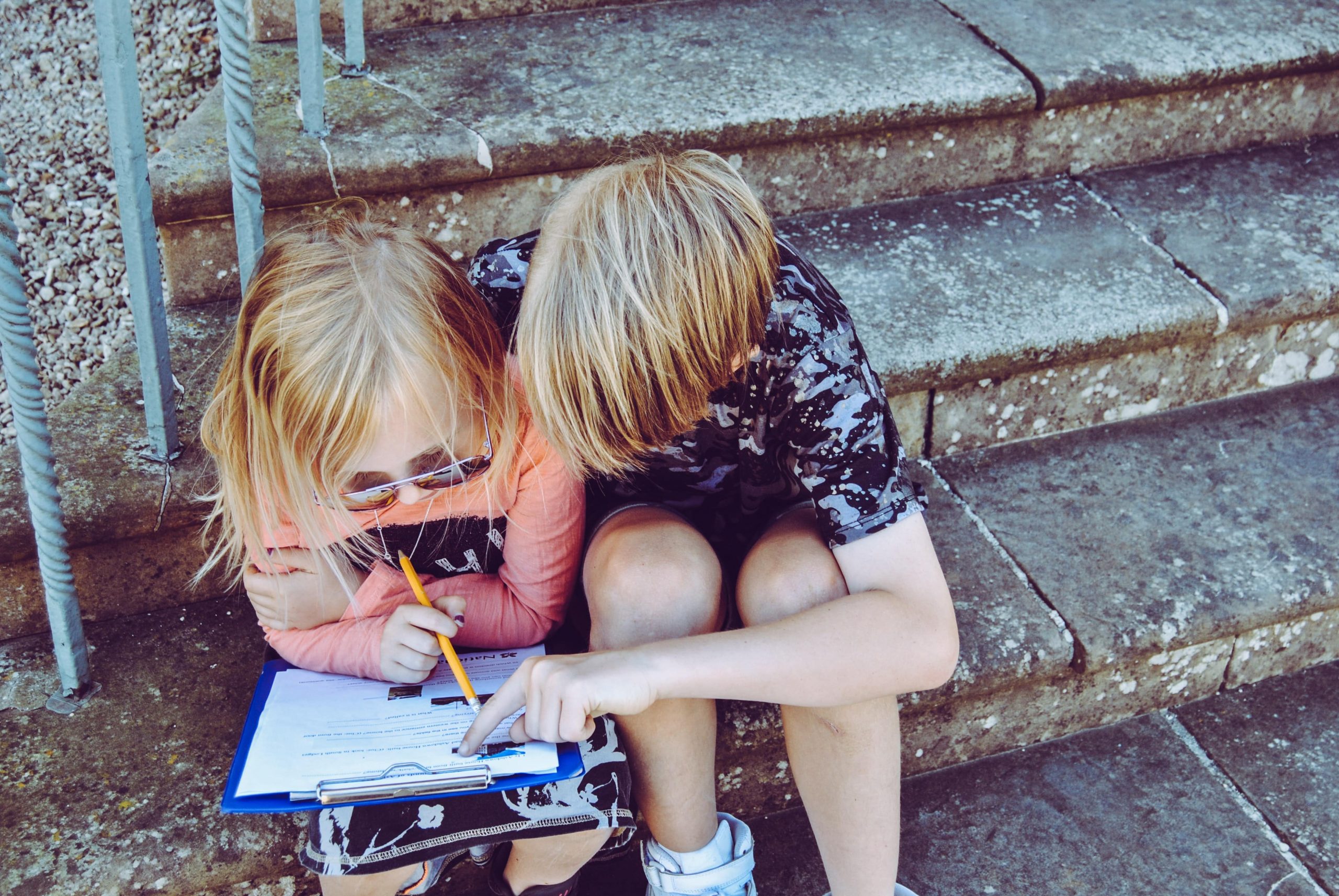 Two kids looking at a clipboard.